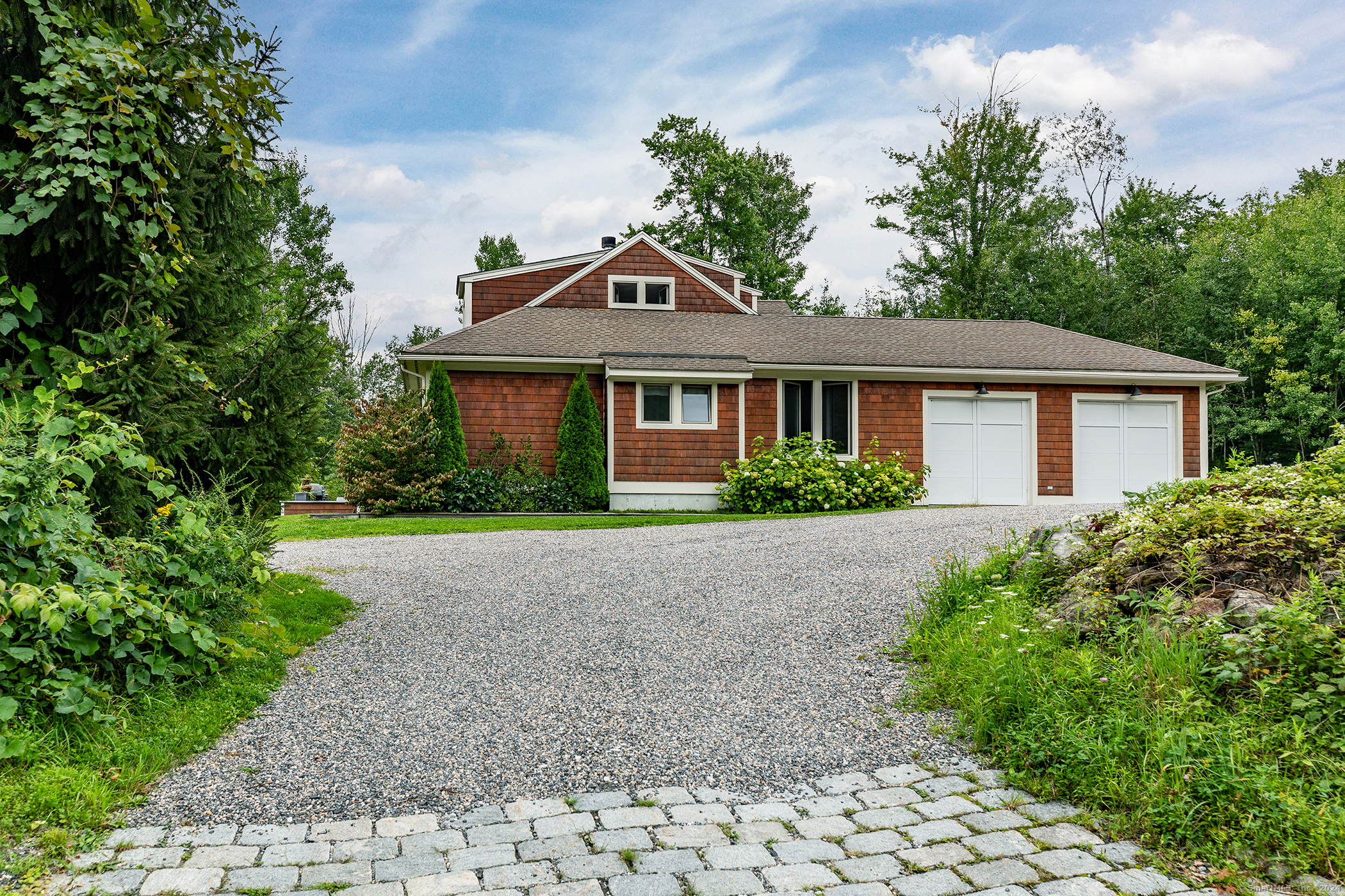 a front view of a house with a garden