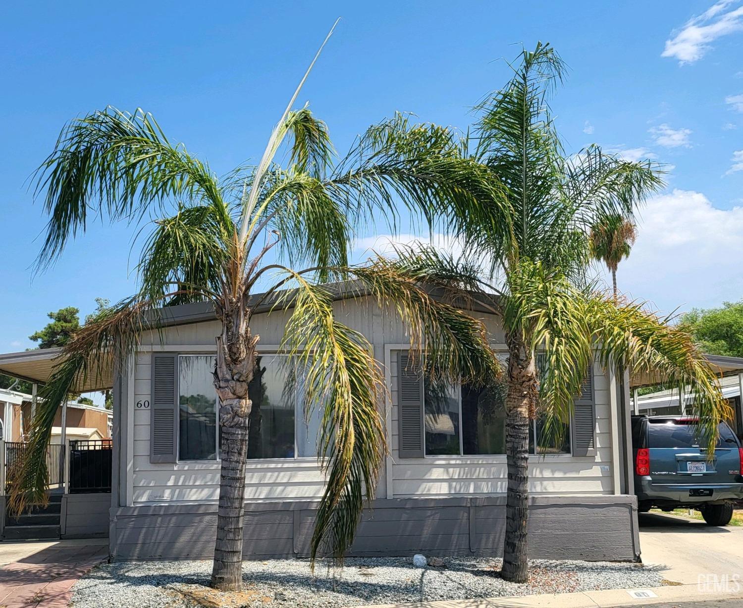 a front view of multiple houses with palm trees