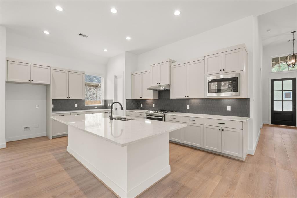 a large white kitchen with cabinets