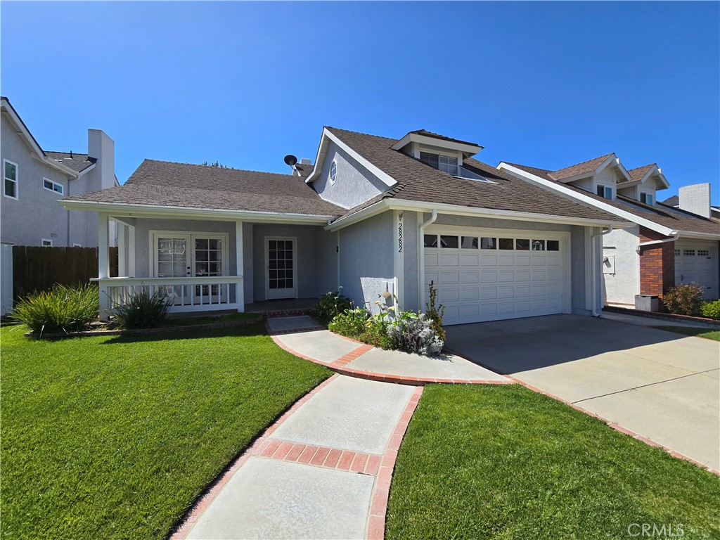 a front view of a house with a garden and yard