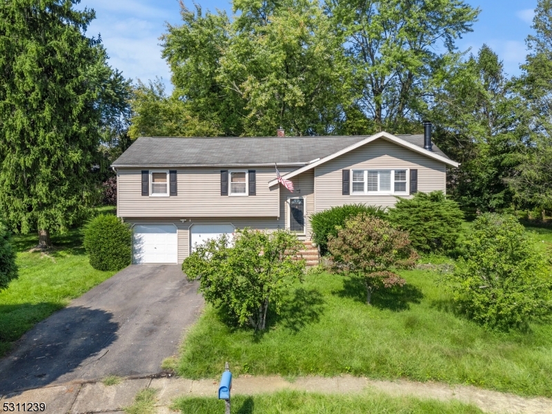 a front view of a house with a yard and trees