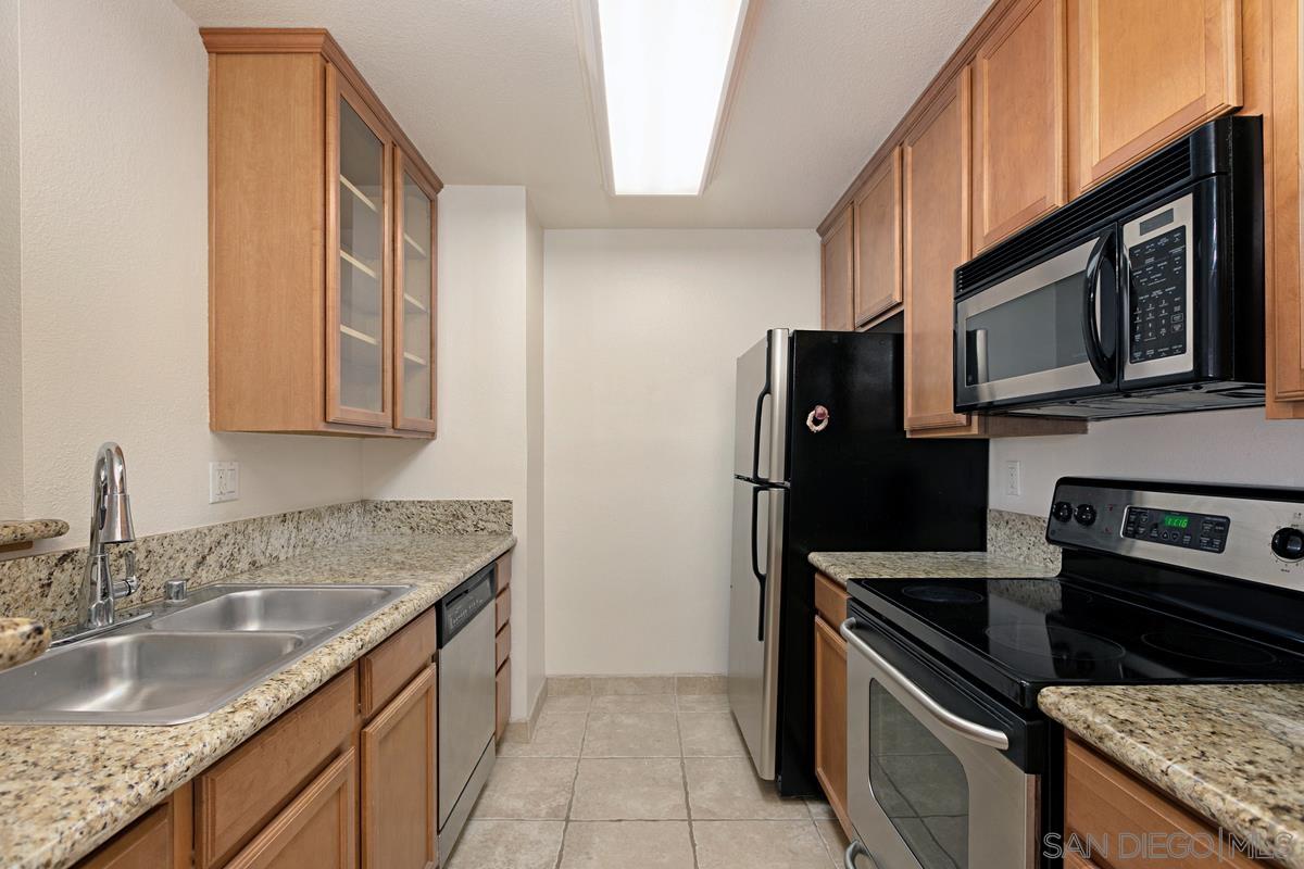 a kitchen with granite countertop a sink stove and refrigerator