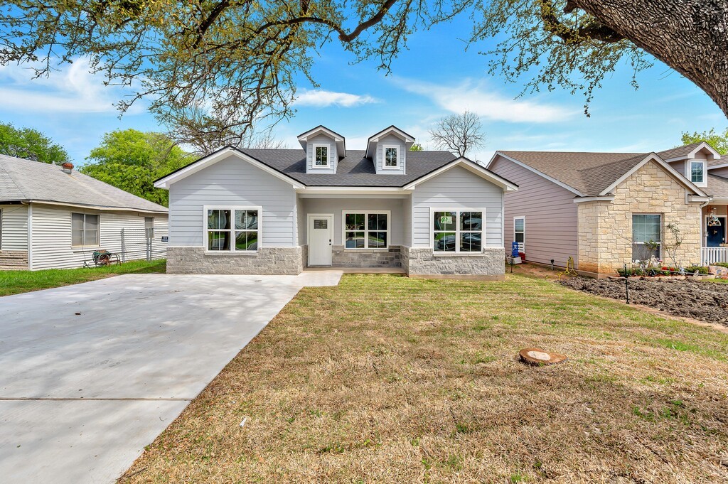 a front view of a house with a garden and yard