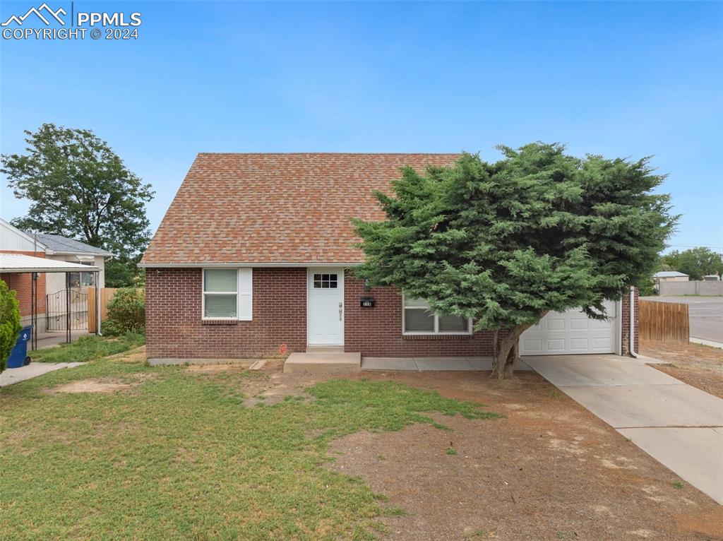 a front view of a house with a yard and trees