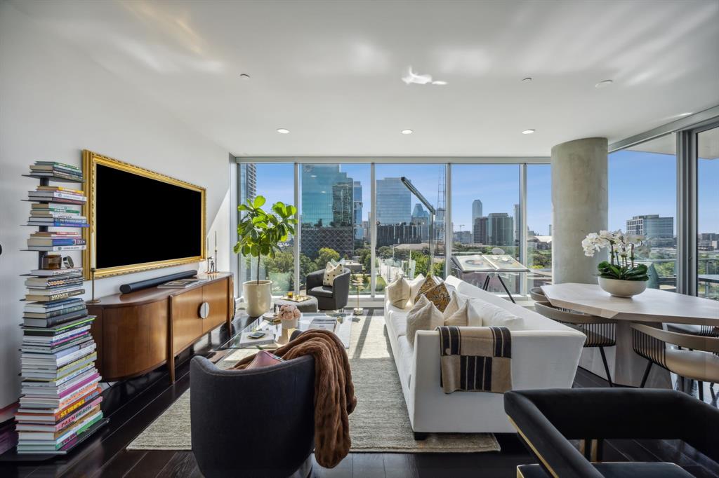 a living room with furniture a flat screen tv and a large window