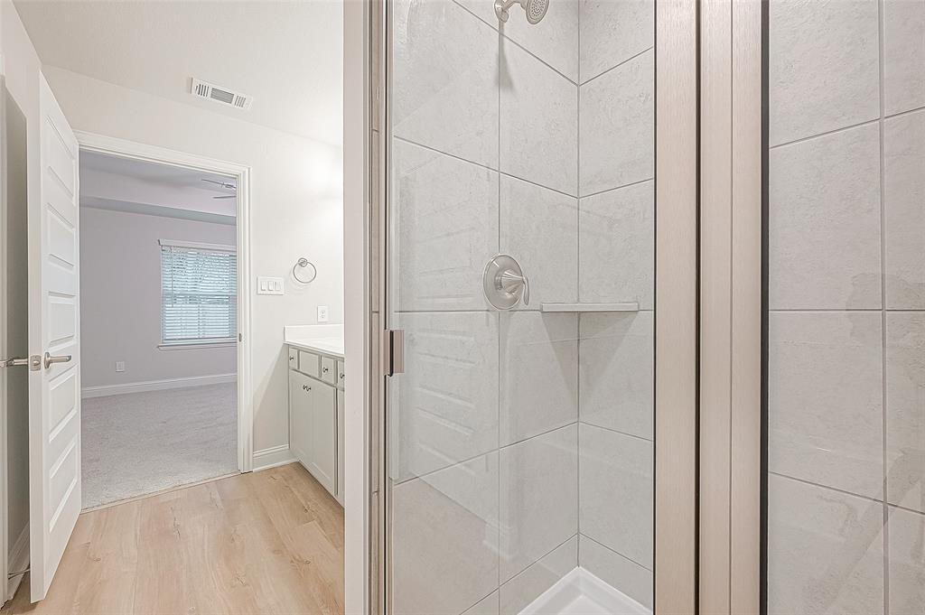 a bathroom with a shower and a glass door