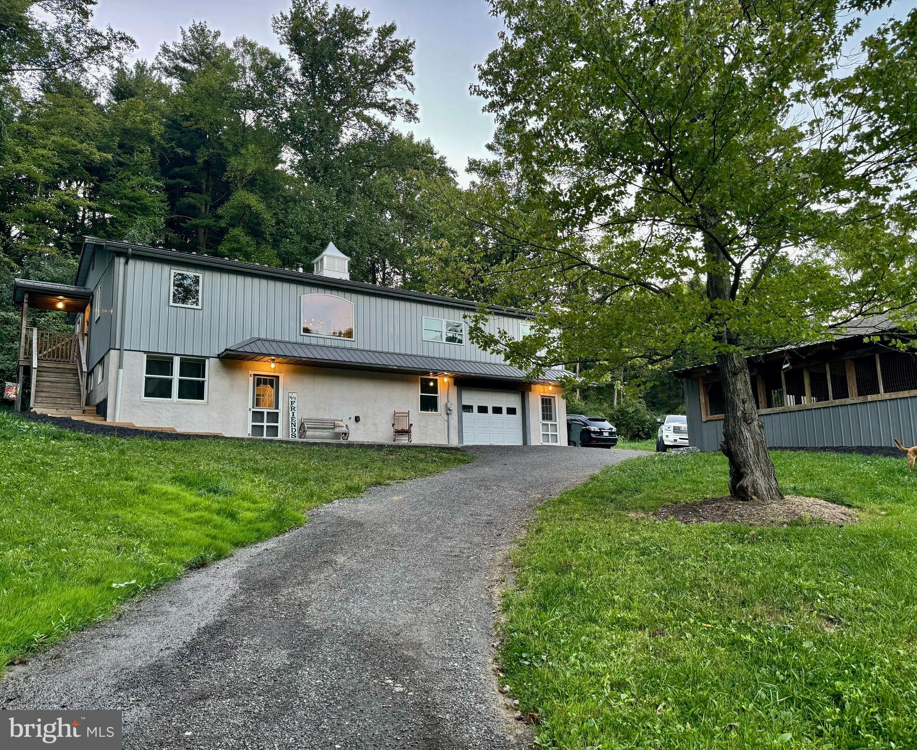 a front view of a house with a yard and trees