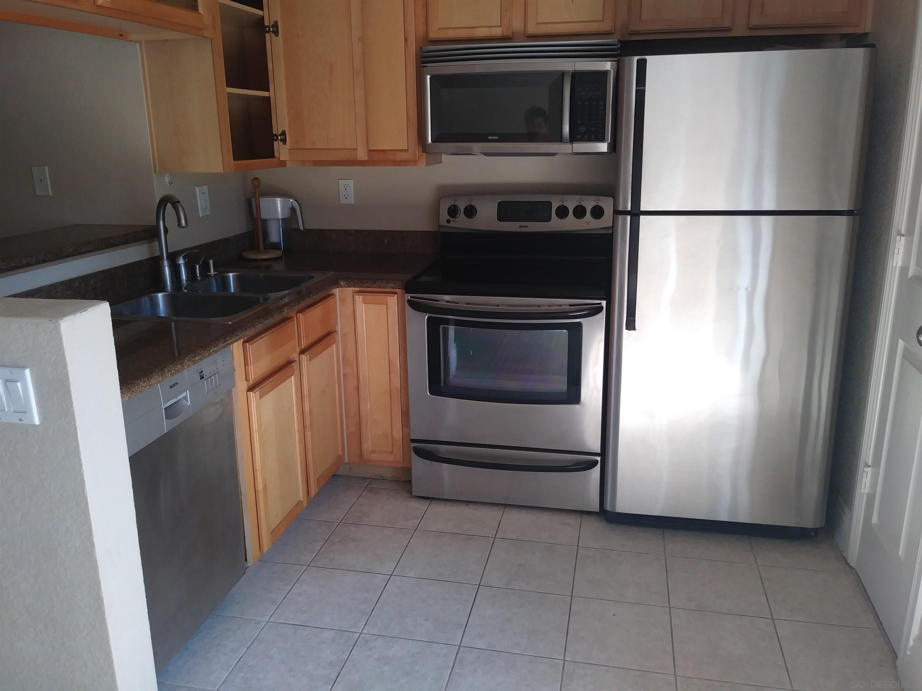 a kitchen with granite countertop a refrigerator and a stove