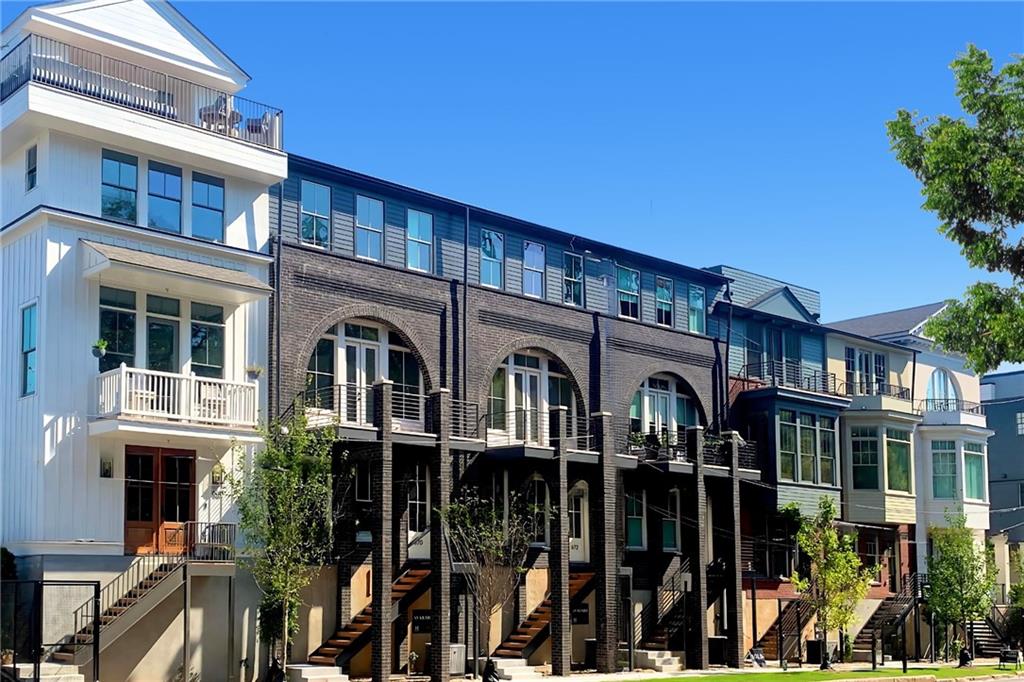 a front view of a building with glass windows and plants