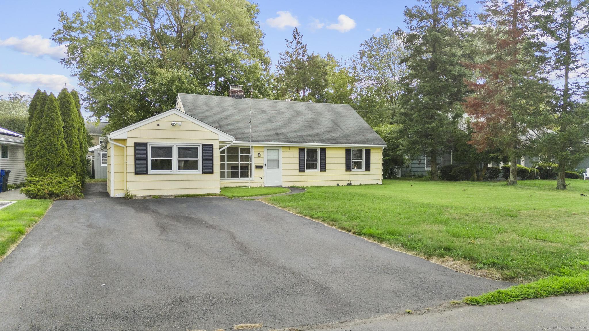 a front view of a house with yard and green space