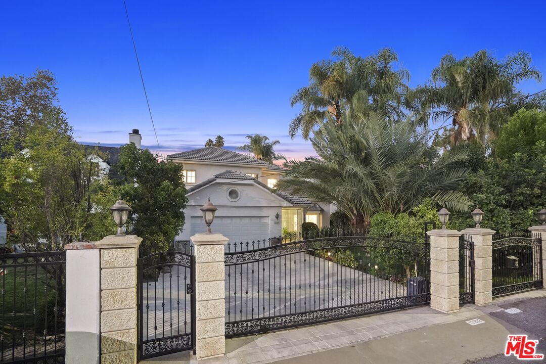 a view of a house with a small yard and a palm tree