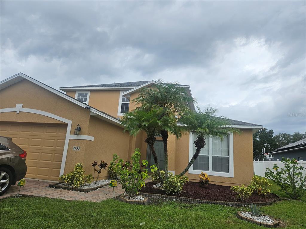 a front view of a house with a garden and plants