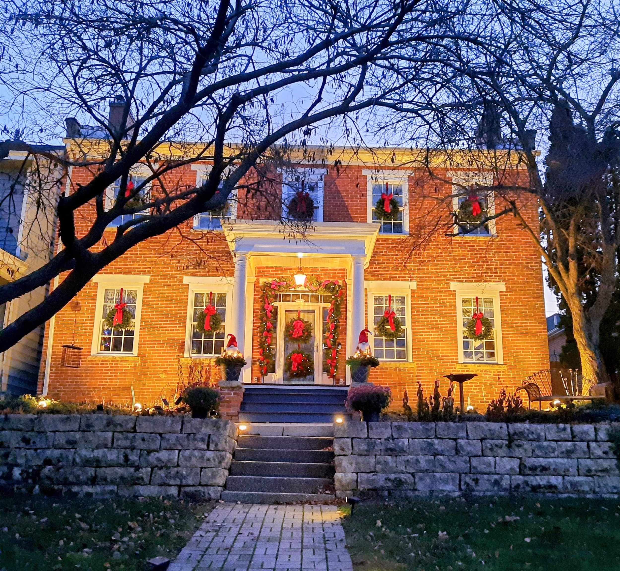 a front view of a house with a tree