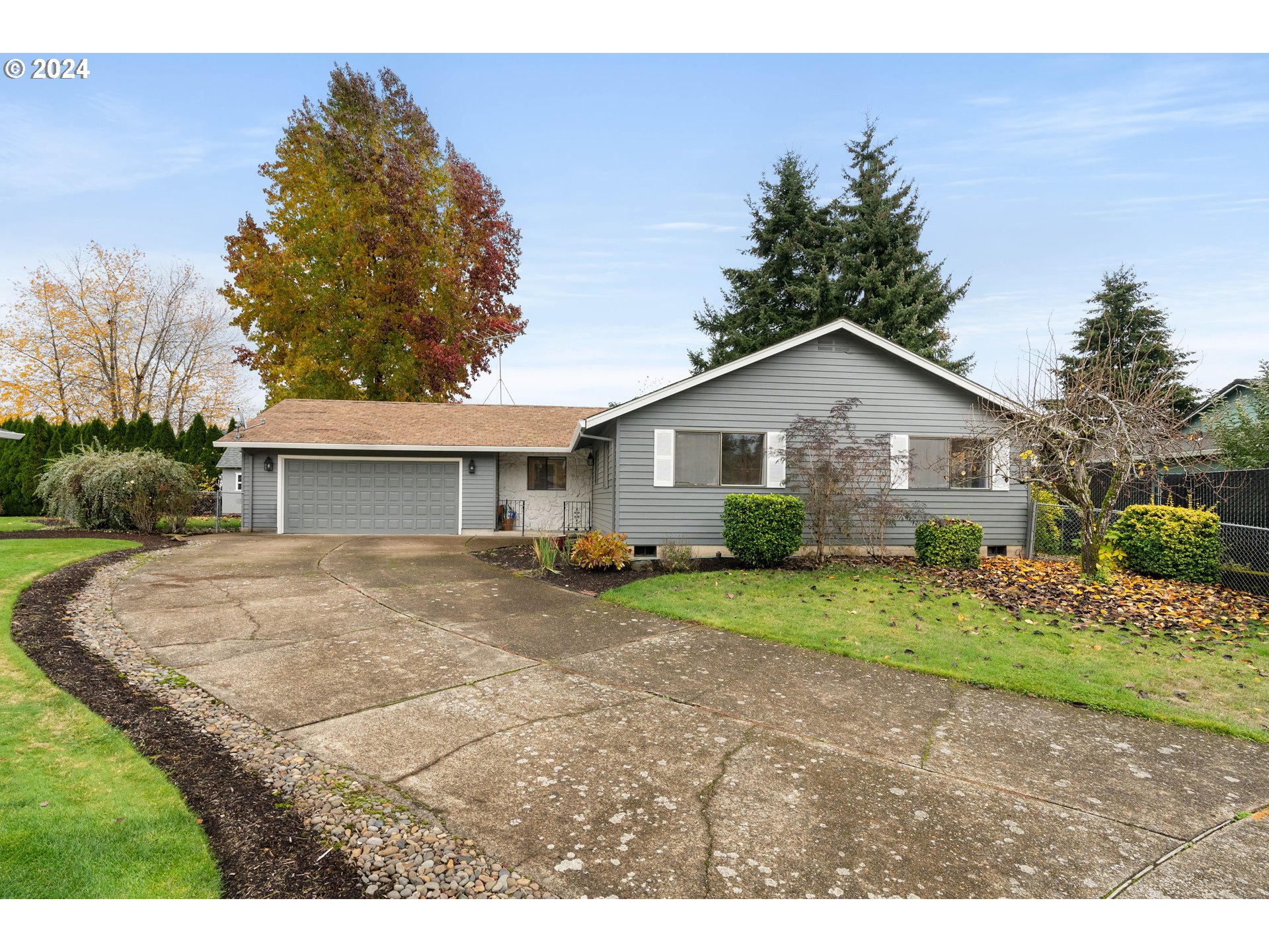 a view of a yard in front of a house with large trees