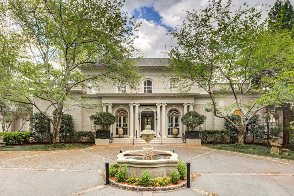 a view of a house with fountain in front of it