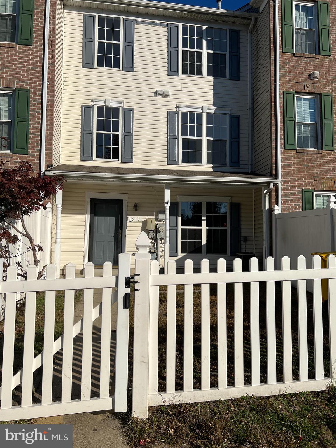 a view of a brick house with wooden fence