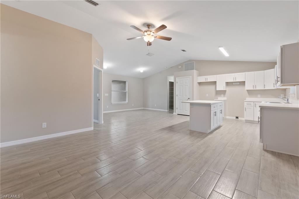 a view of an empty room with a kitchen