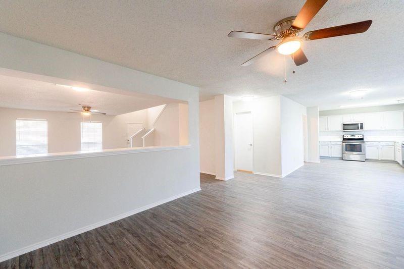 a view of an empty room with window and wooden floor