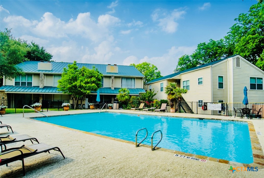 a view of a house with swimming pool and sitting area