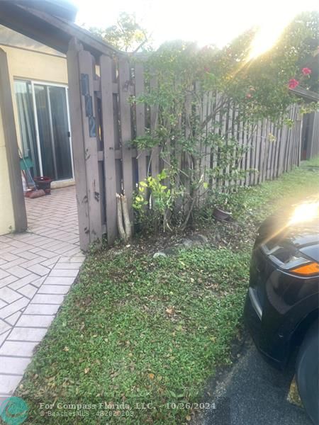 a view of a backyard with plants and wooden fence