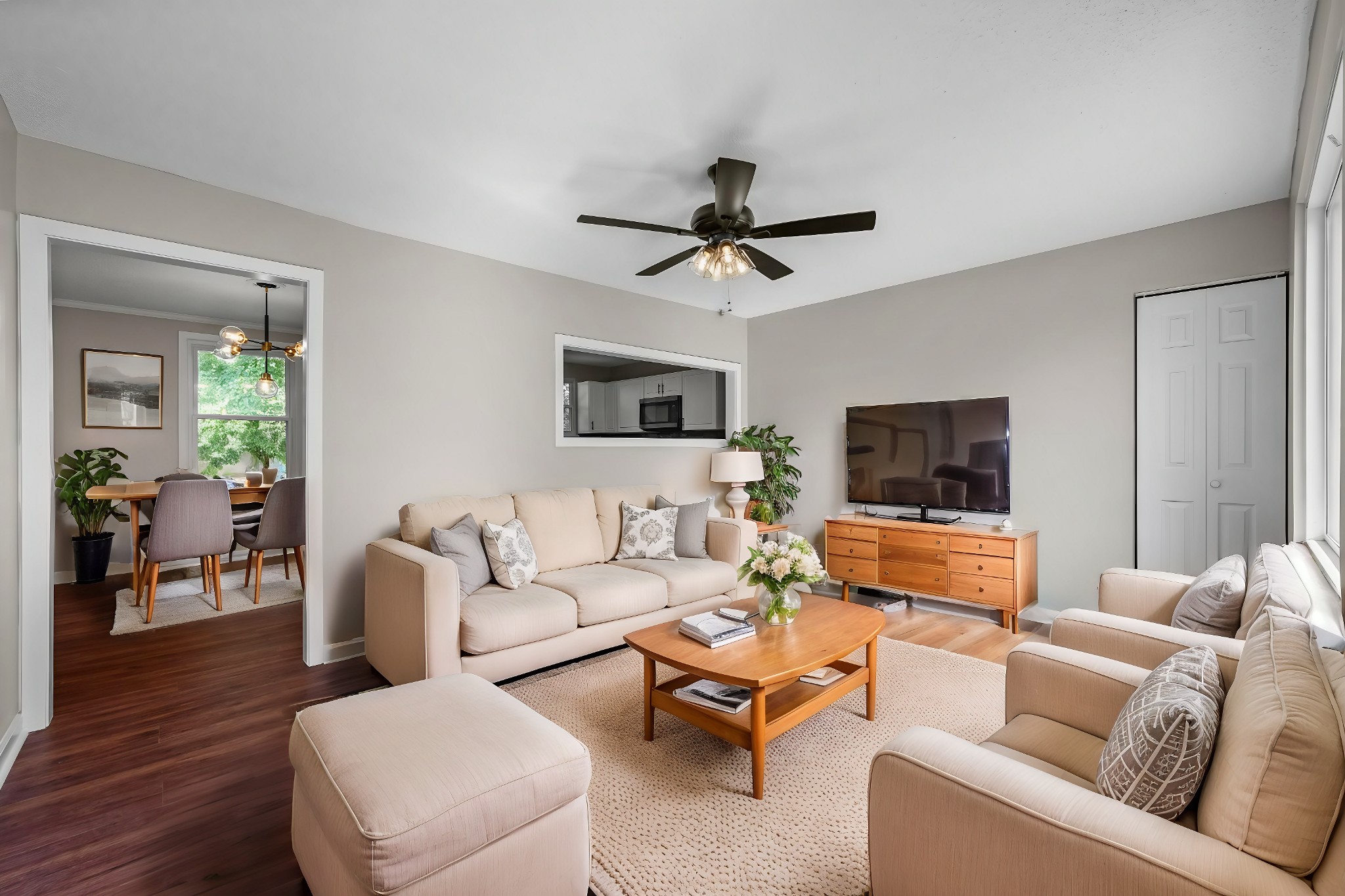 a living room with furniture a ceiling fan a flat screen tv and a window