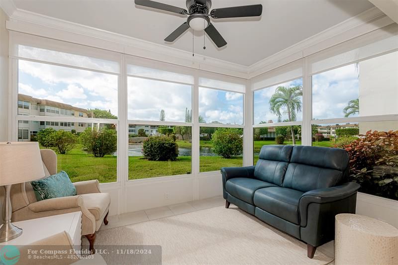 a living room with patio furniture and a garden