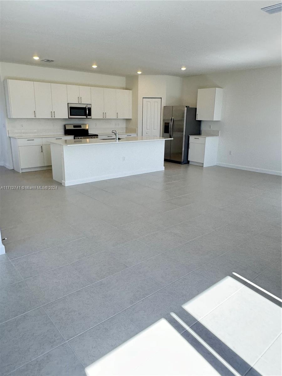 a kitchen with stainless steel appliances a refrigerator and a stove top oven