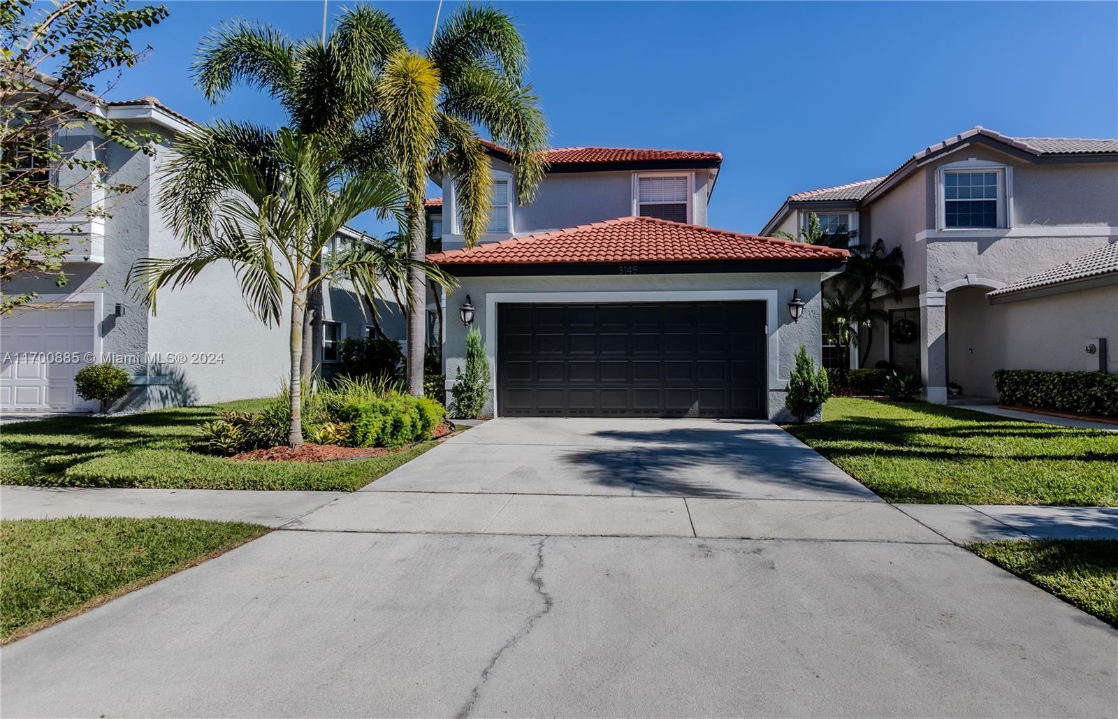 a front view of a house with a yard and a garage