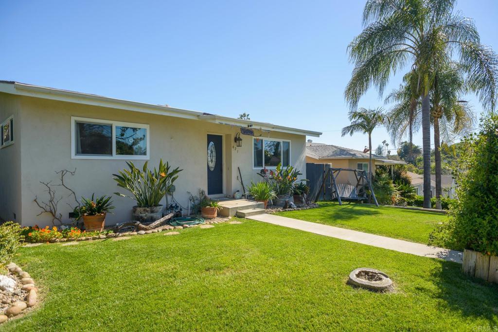 a view of a house with a yard and palm tree