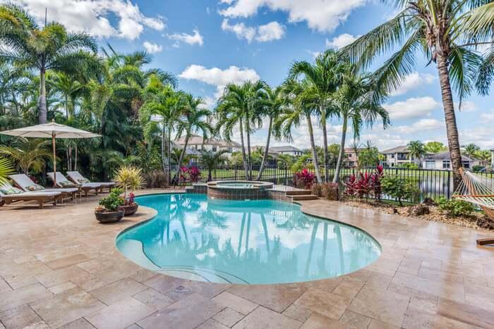 a view of a swimming pool with lounge chairs in a patio