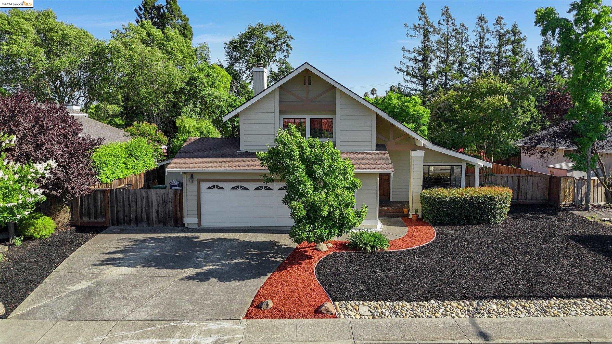 a view of a house with a yard and large tree