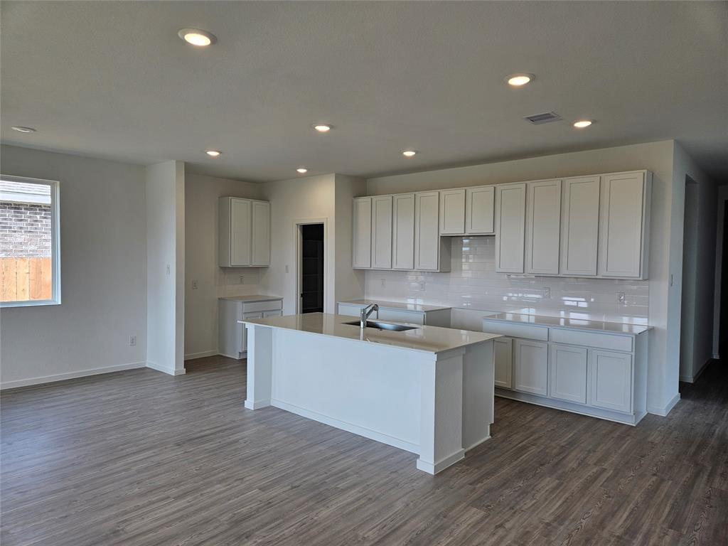 a kitchen with a sink and wooden floor