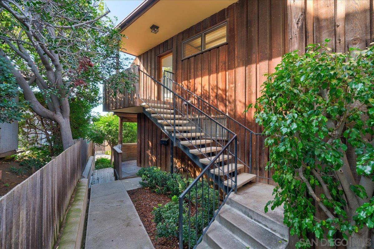 a view of a pathway of a house with wooden fence