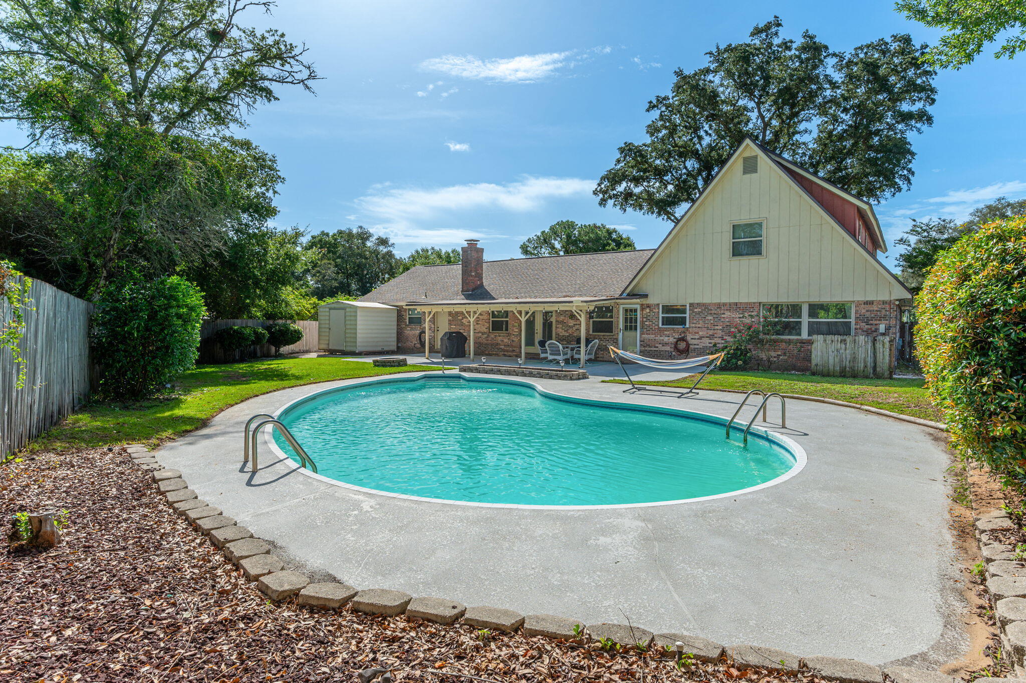 a house view with a swimming pool and garden