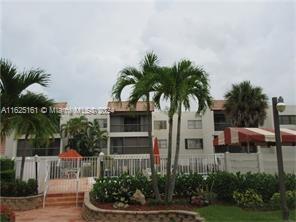 a view of multiple houses with a yard and potted plants