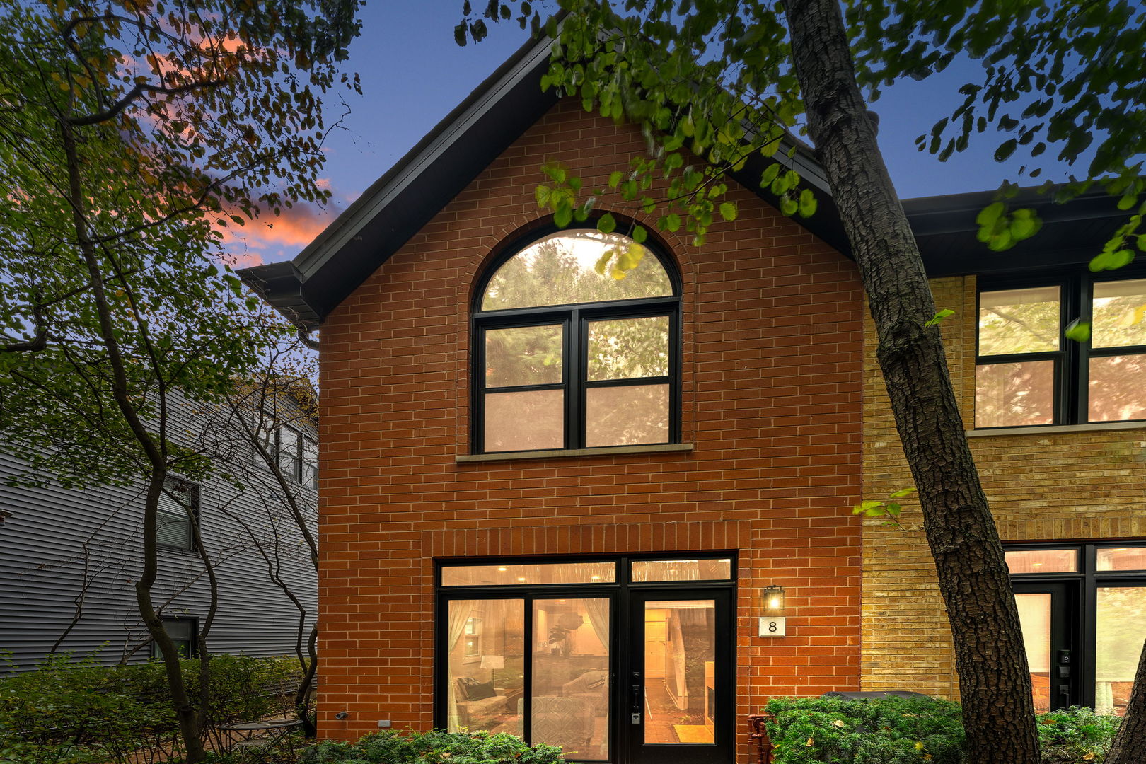 a front view of a house with a tree