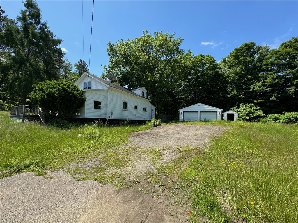 Front with detached garage and shed