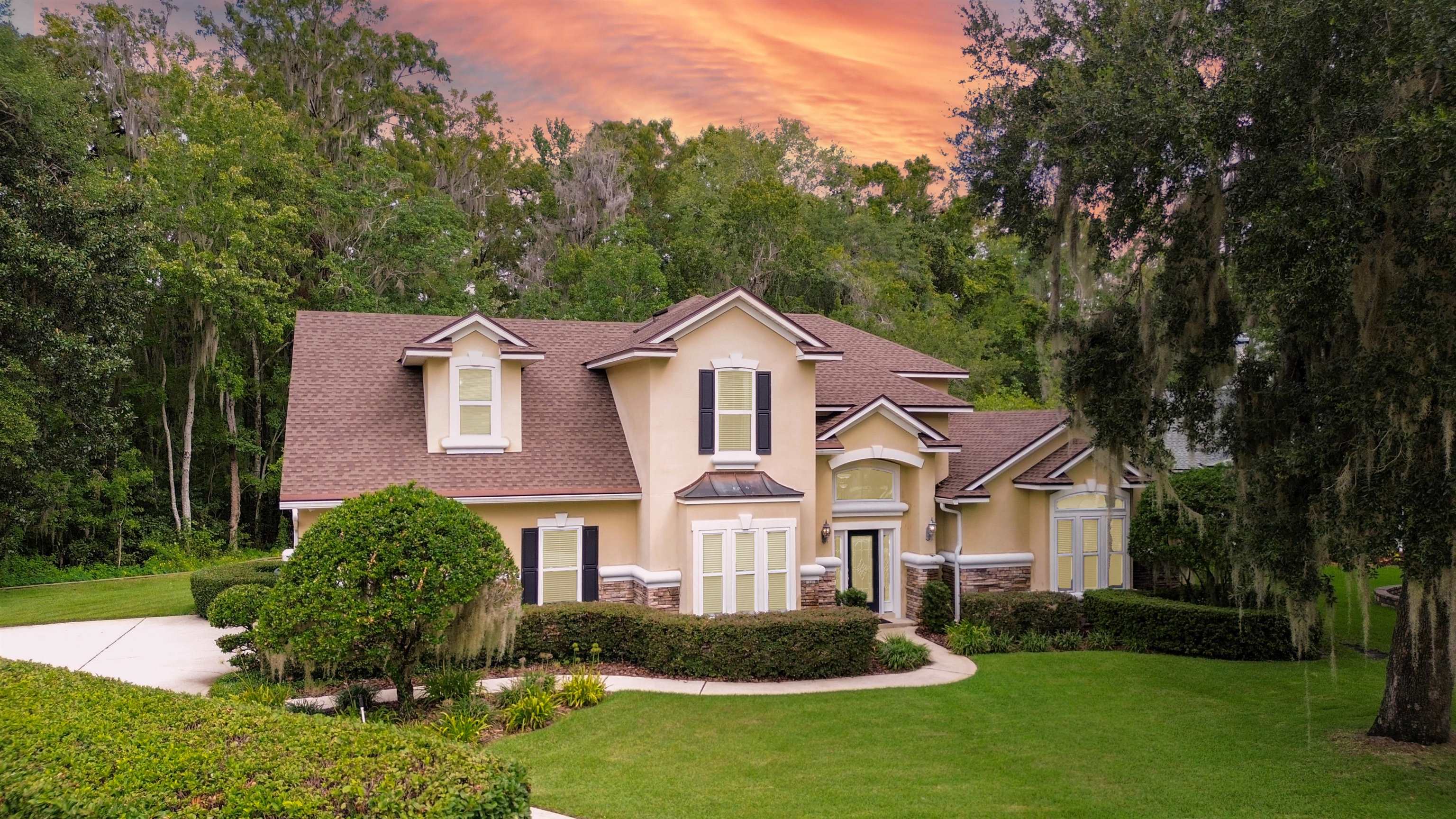 a front view of a house with a garden