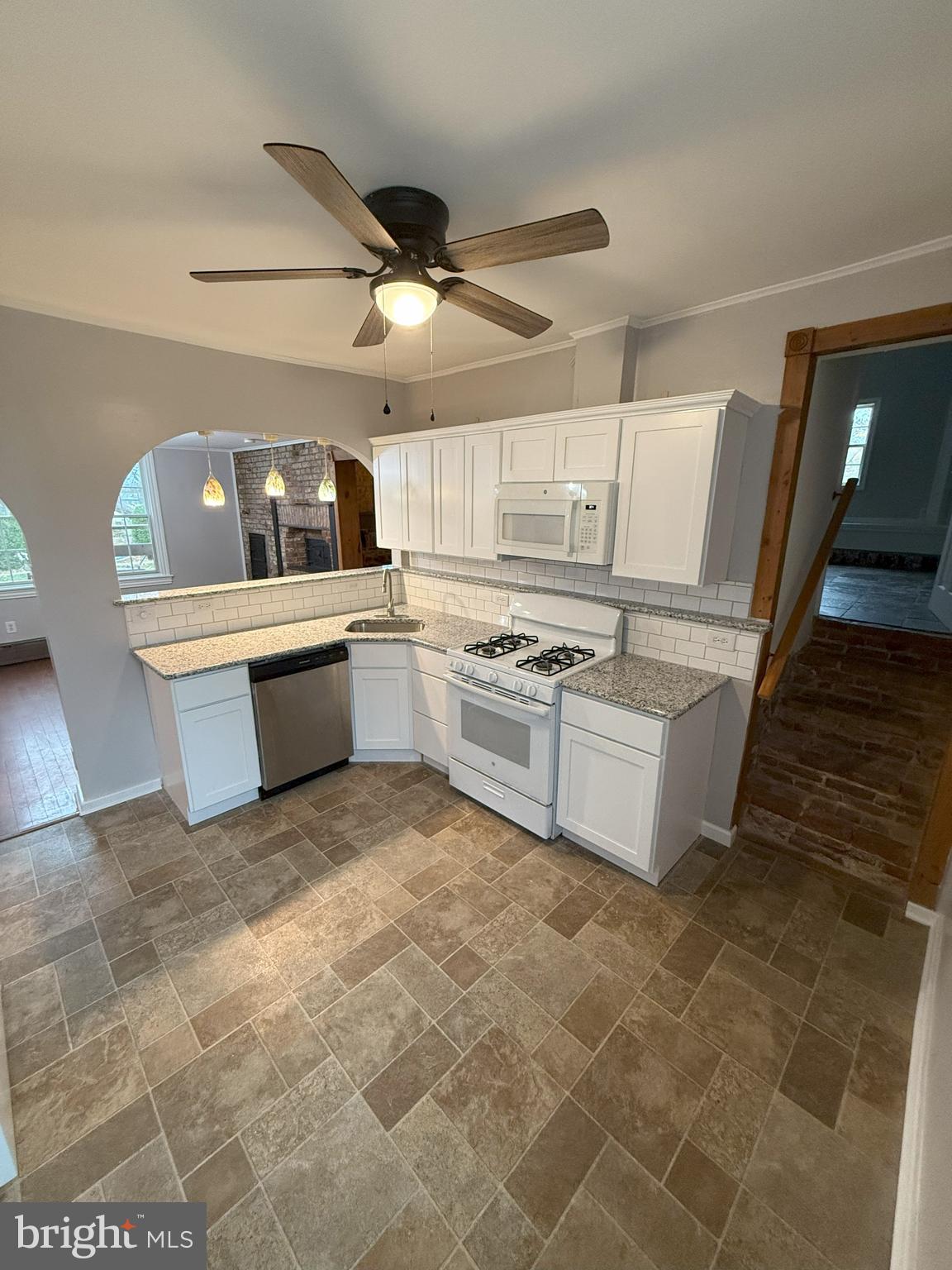 a kitchen with stainless steel appliances a stove a sink and white cabinets