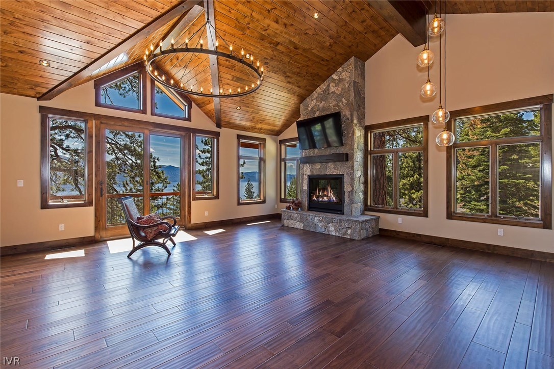 a view of a work room with wooden floor a fireplace and window