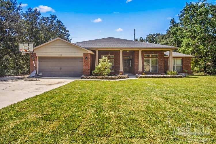 a front view of a house with a yard outdoor seating and garage