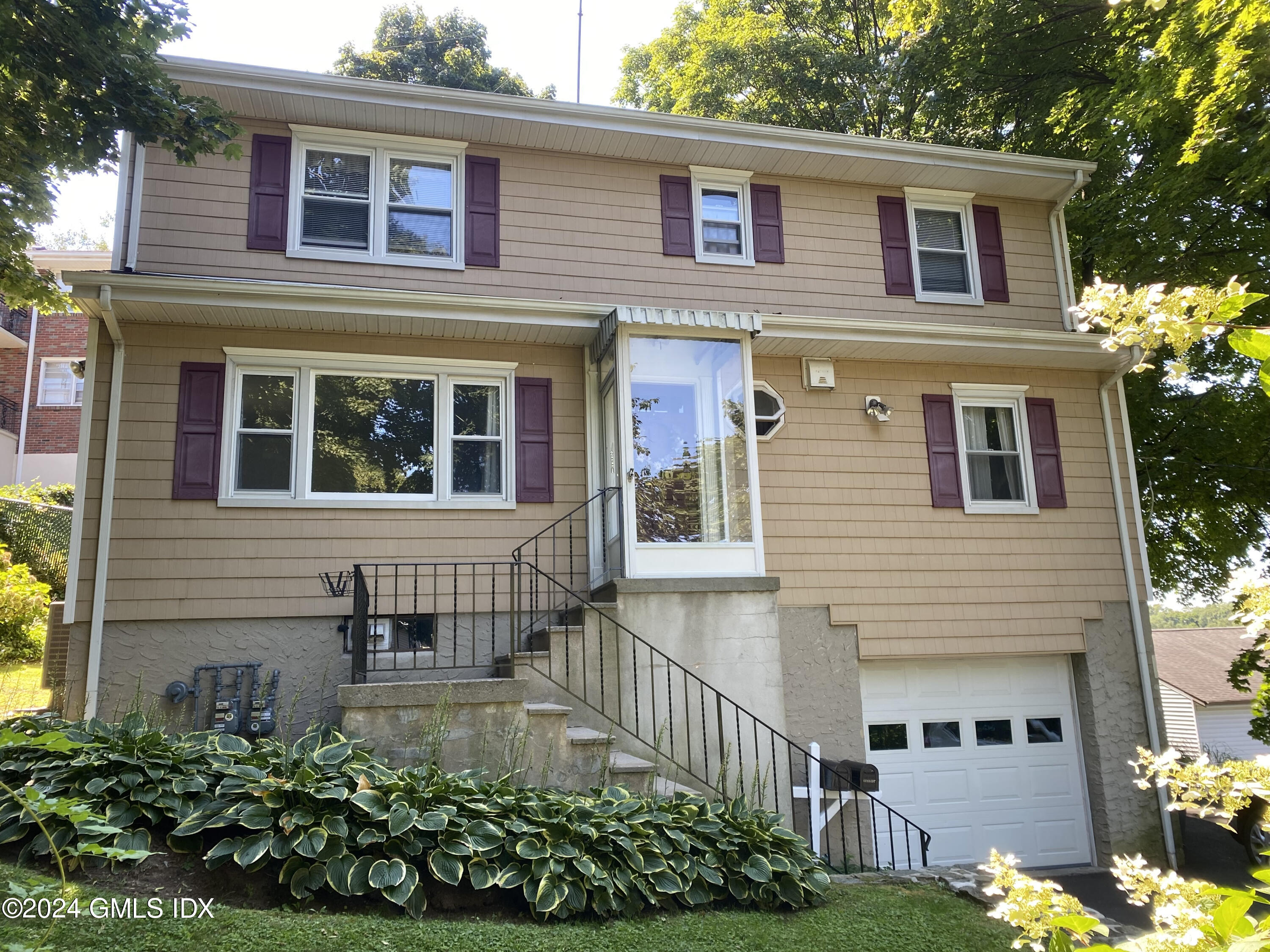 a front view of a house with a garden