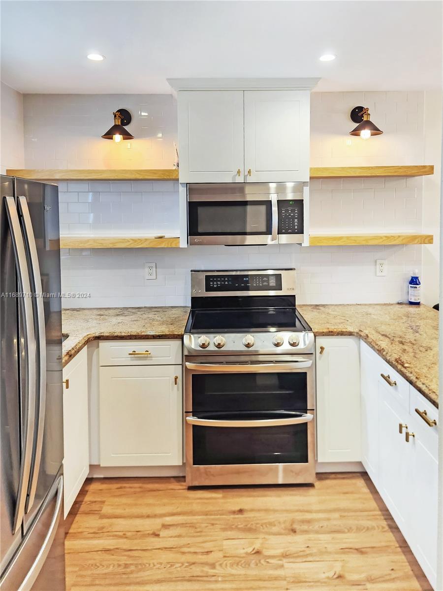 a kitchen with stainless steel appliances granite countertop a stove and a refrigerator