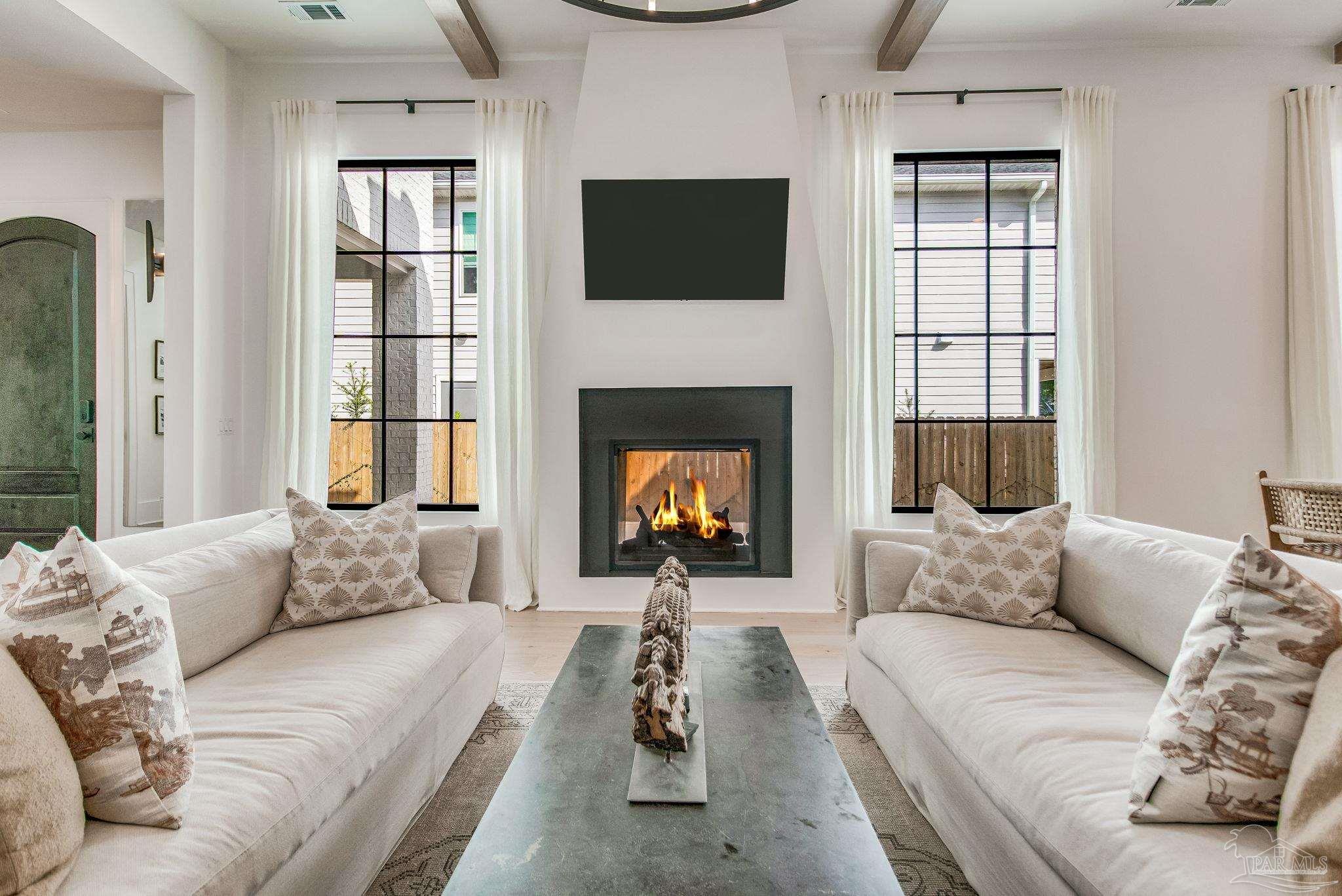 a living room with furniture a fireplace and a flat screen tv