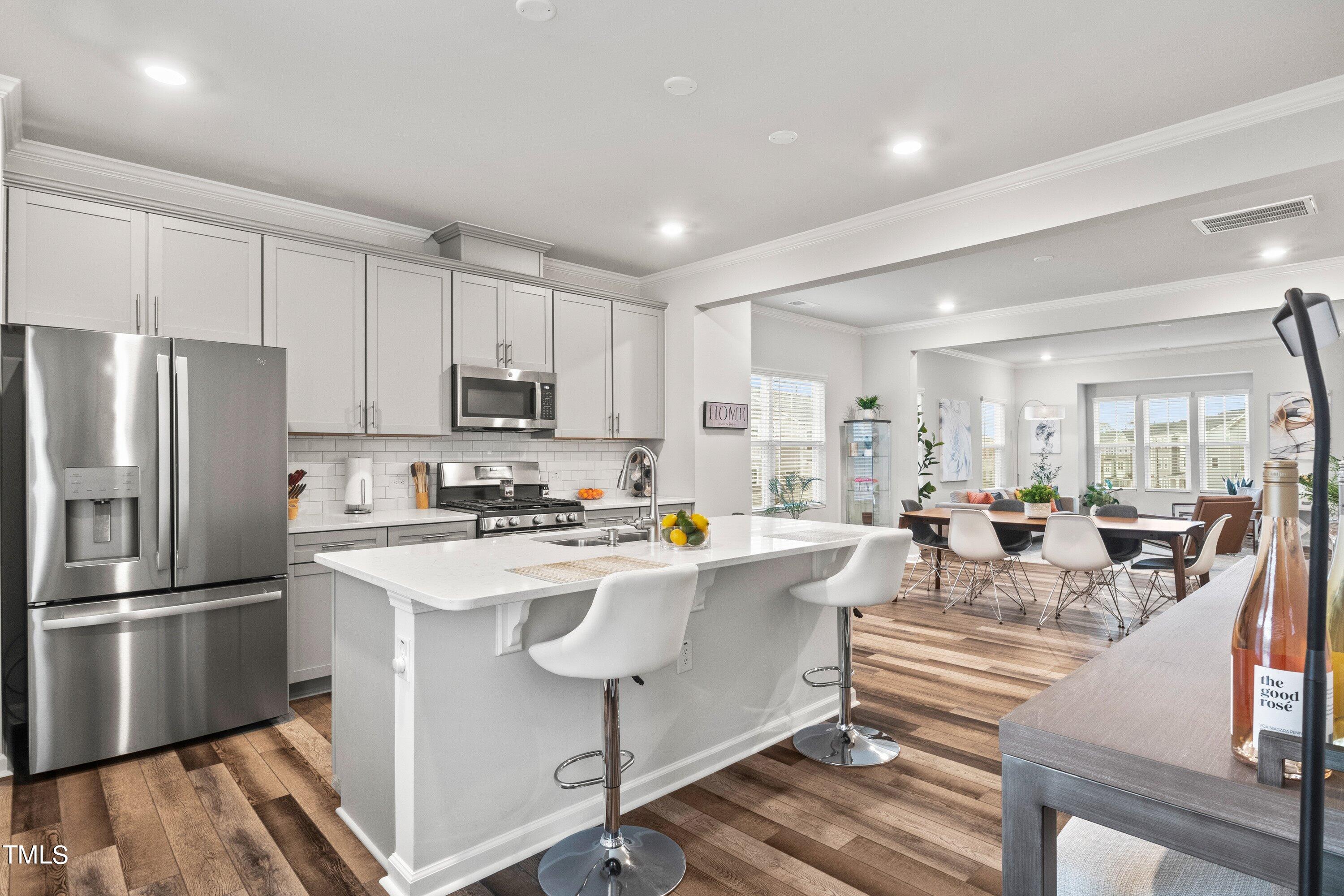 a view of kitchen with stainless steel appliances granite countertop a stove and a refrigerator