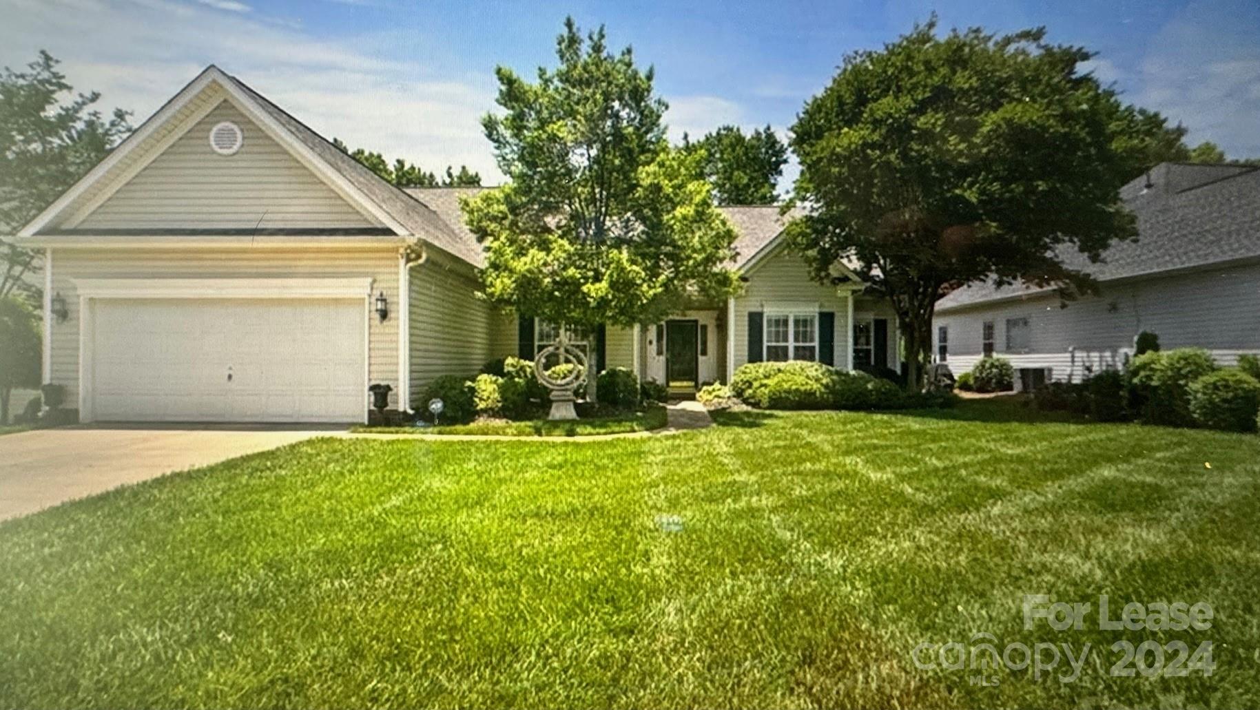 a front view of a house with a yard and trees