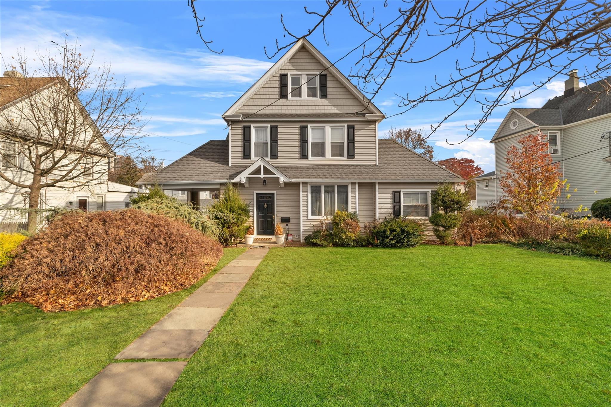 View of property featuring a front lawn