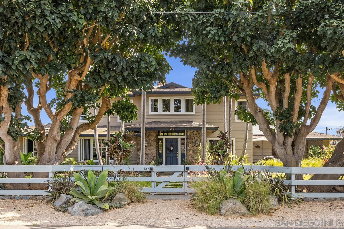 a front view of a house with a tree in it