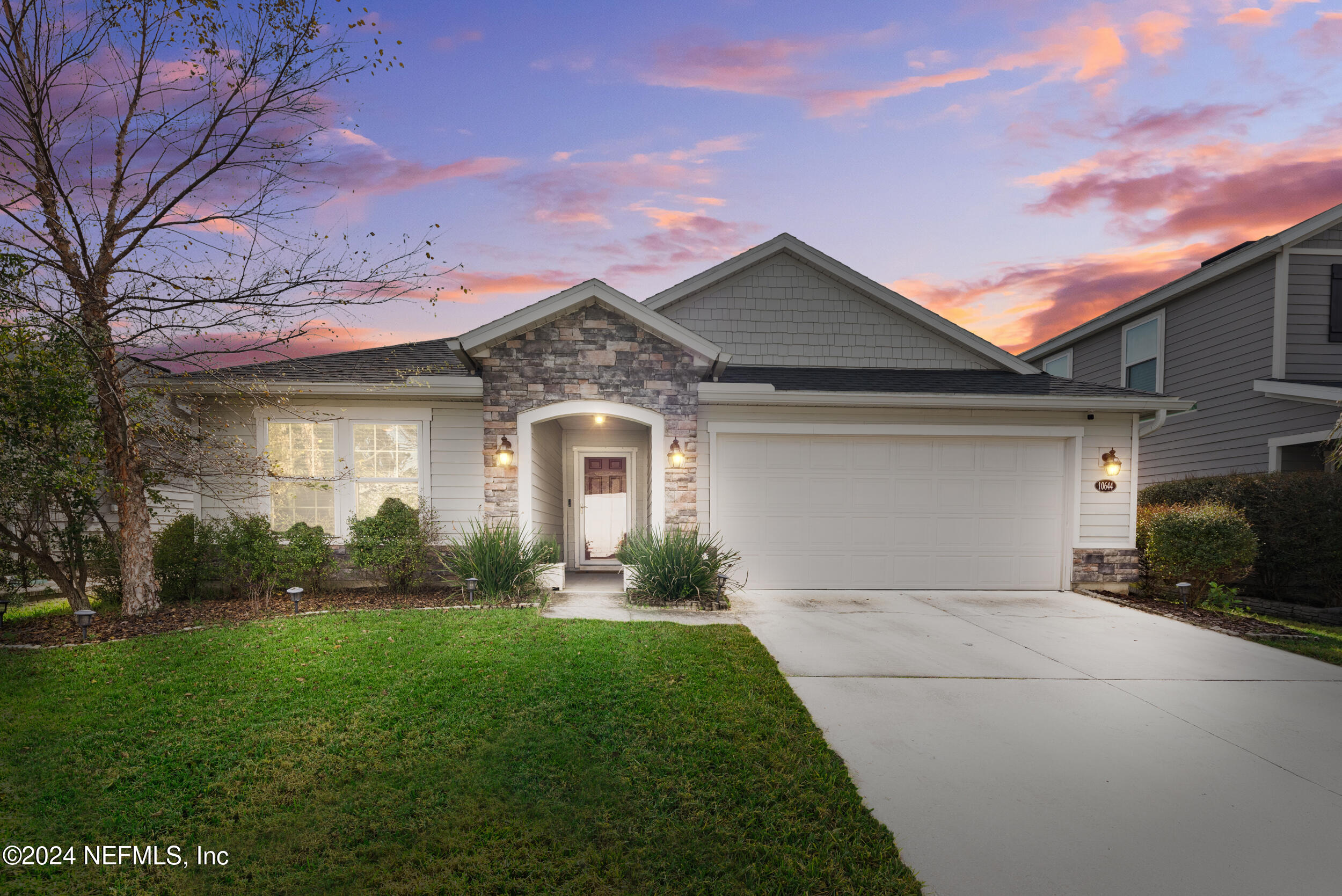 a front view of a house with a yard and garage