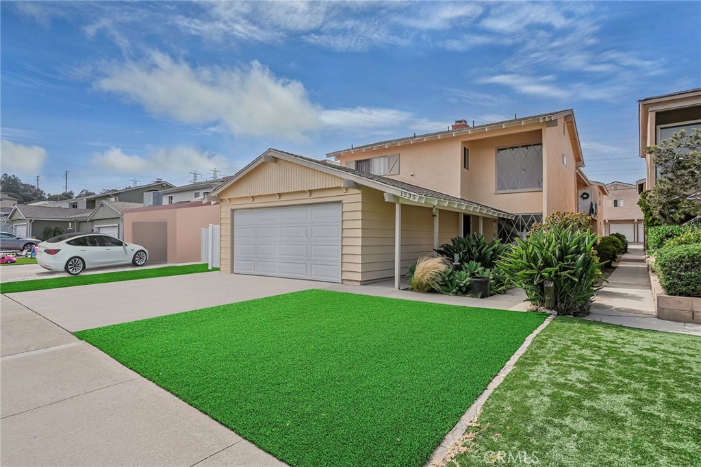 a front view of a house with a garden and yard